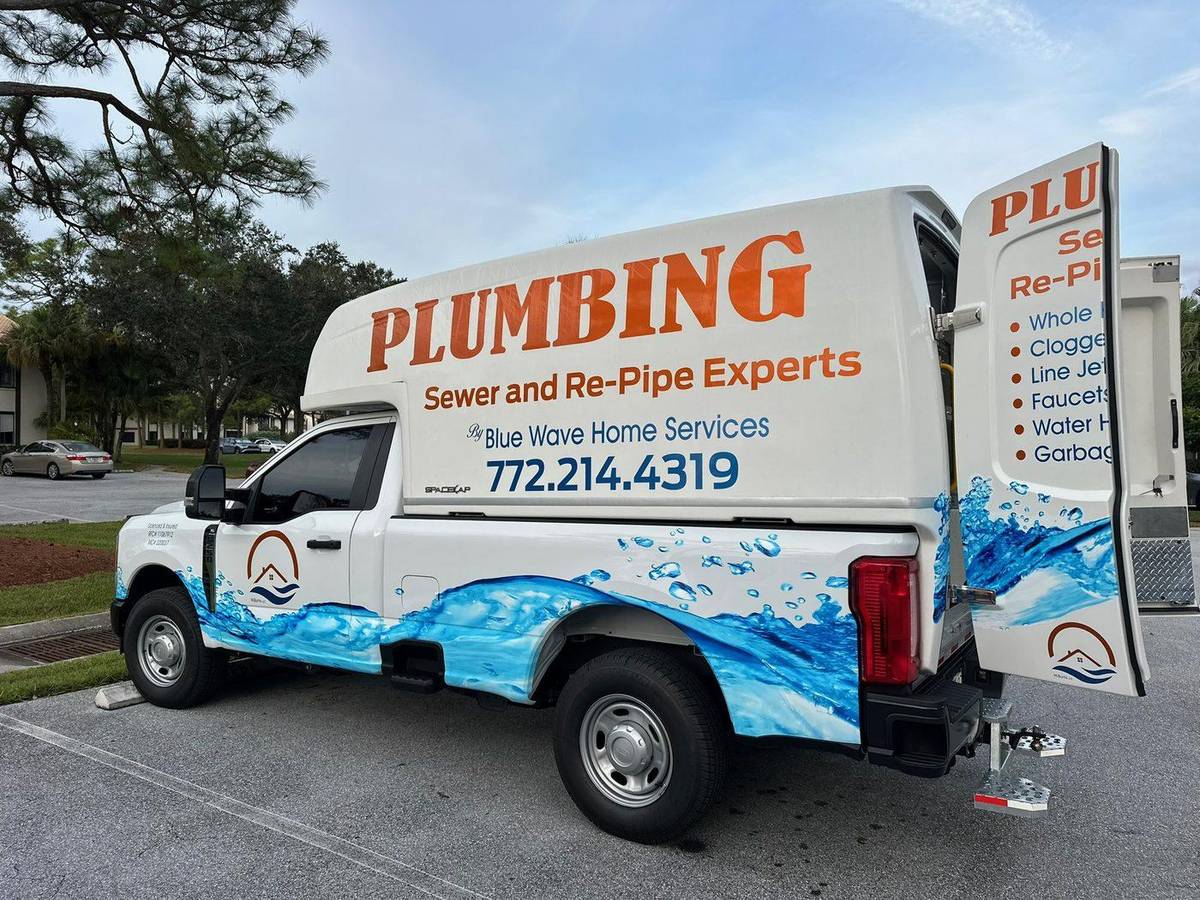 Blue Wave Home Services truck listing plumbing, sewer, water heater and repipe services